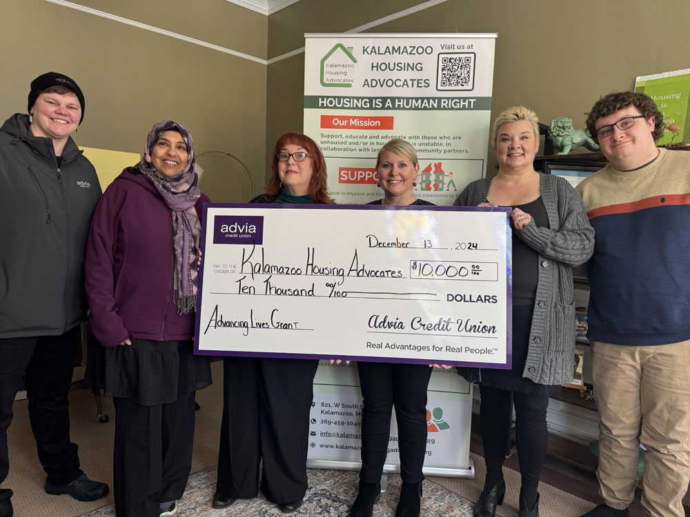 A group of people with a large check from Advia Credit Union