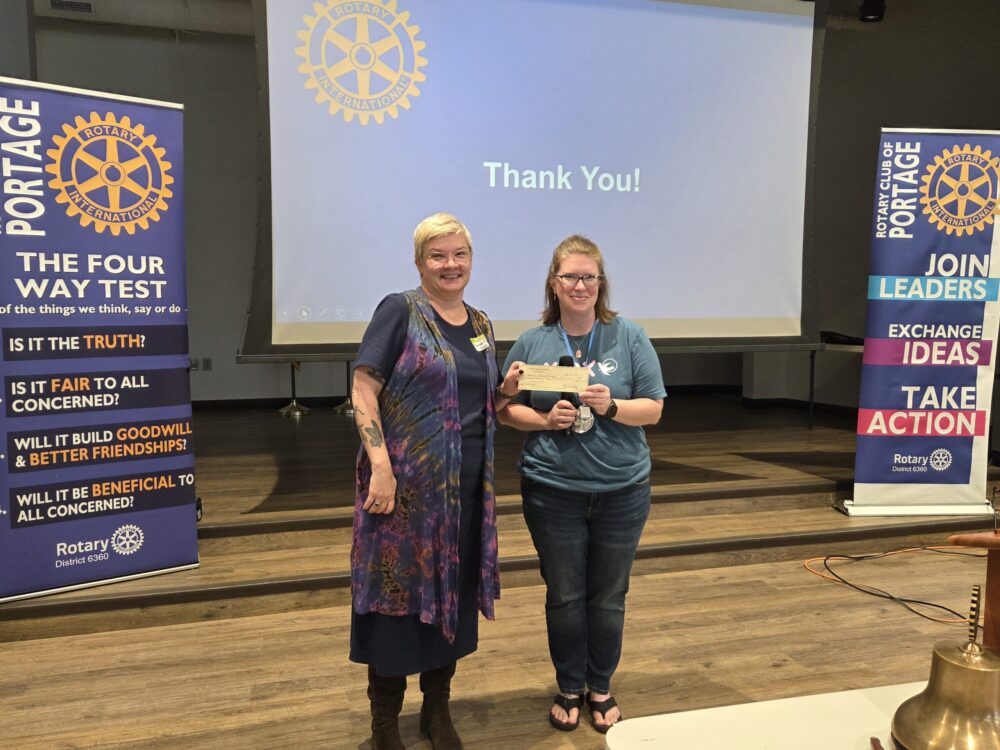 KHA Executive Director Sarah Cain receiving a check from Rotarian Sarah Gerstner